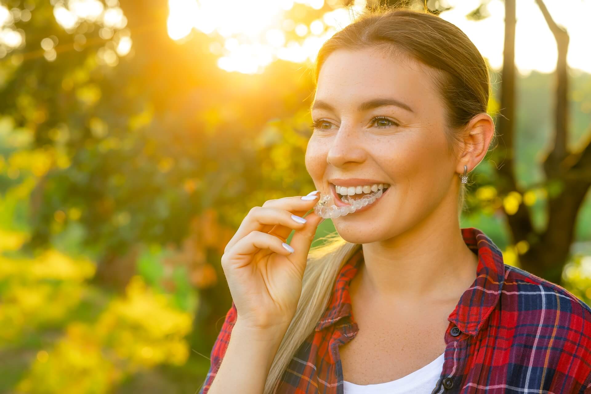 Photo of a person with Invisalign® smiling outdoors