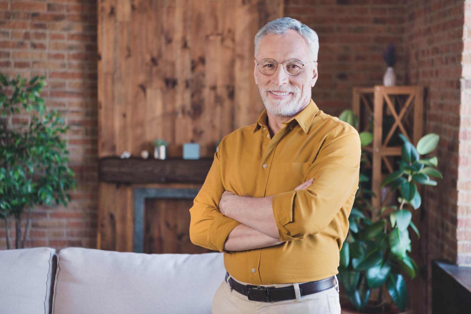 Photo of a senior man smiling while standing in a room