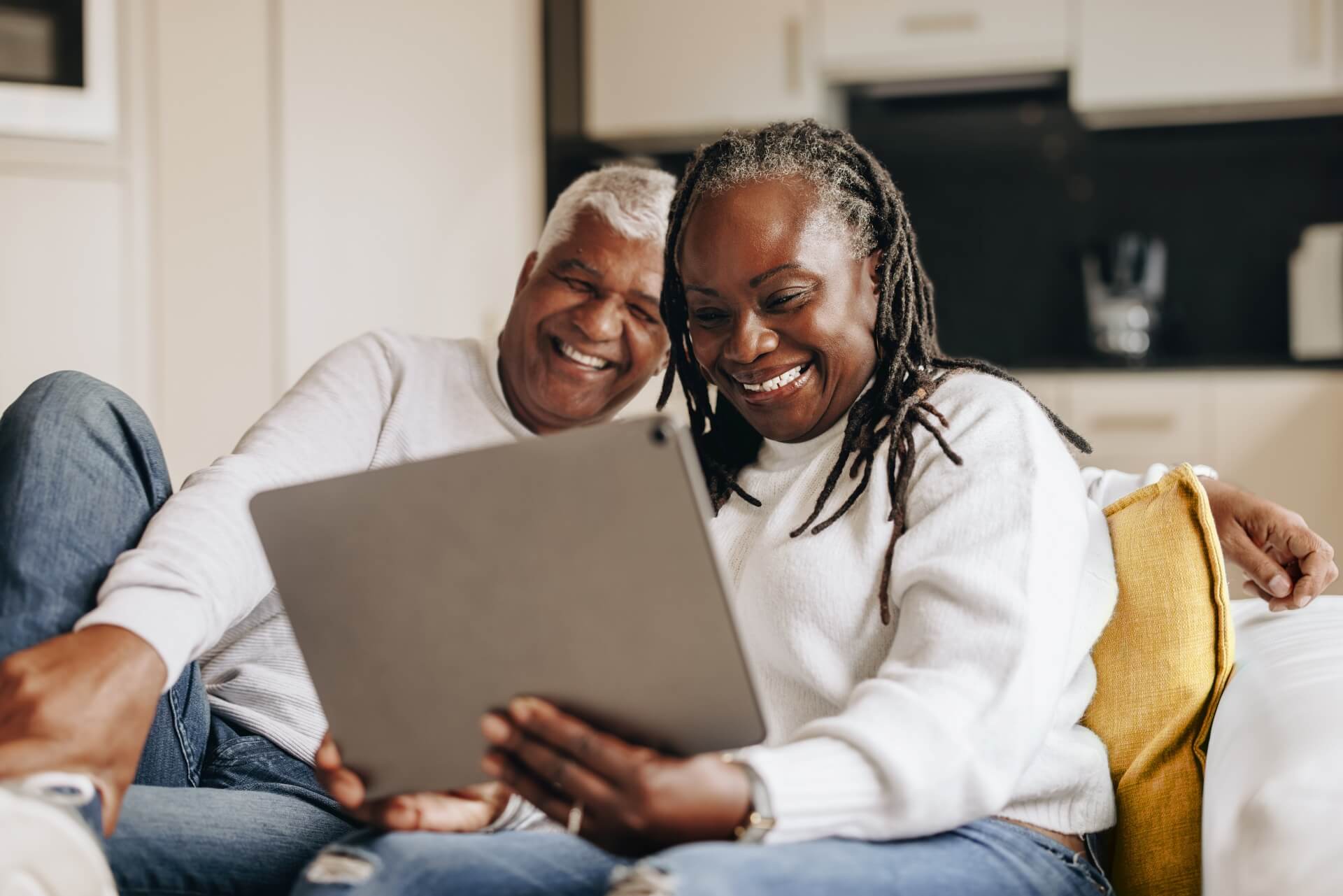 See how restorative dentistry works A mature couple looking at their tablet on the sofa