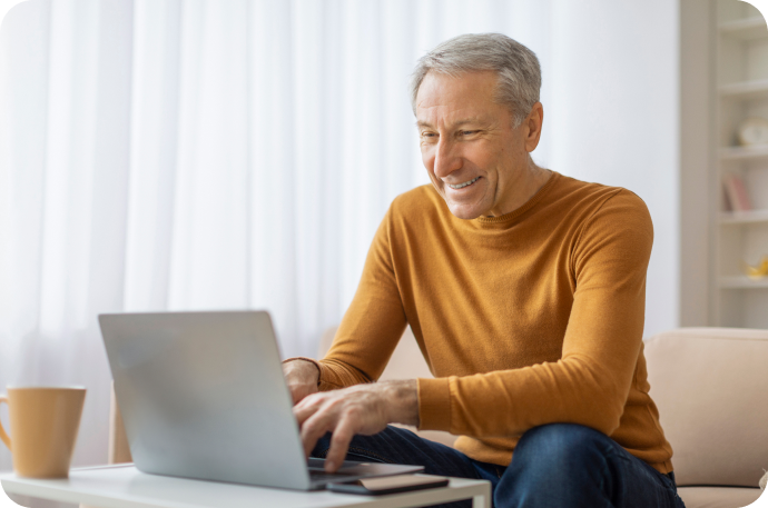 Image of an elderly man working on a laptop